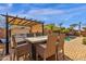 Outdoor dining area with pergola, string lights, and backyard view including hot tub and swimming pool at 2463 E Stacey Rd, Gilbert, AZ 85298