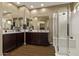 Bathroom featuring a double sink vanity with a large mirror and a walk-in shower with glass doors at 25907 N 134Th Dr, Peoria, AZ 85383