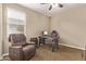 Cozy bedroom featuring a comfortable chair and a rustic wooden desk with modern tech at 25907 N 134Th Dr, Peoria, AZ 85383