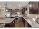 Spacious kitchen featuring dark wood cabinetry, granite countertops, stainless appliances, and wood floors at 25907 N 134Th Dr, Peoria, AZ 85383