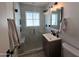 Modern bathroom featuring a glass shower, marble tile, a dark vanity, and updated fixtures at 2946 E Flower St, Phoenix, AZ 85016