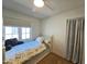 Cozy bedroom with a white twin bed, neutral walls, light window, and a ceiling fan at 2946 E Flower St, Phoenix, AZ 85016