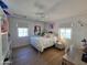 Bright bedroom with wood floors, white furniture, a ceiling fan, and natural light from two windows at 2946 E Flower St, Phoenix, AZ 85016