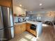 Open-concept kitchen with stainless steel refrigerator, white countertops, and natural wood cabinets at 2946 E Flower St, Phoenix, AZ 85016