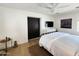 Cozy bedroom with hardwood floors, ceiling fan, modern light fixtures and a stylish sliding black door at 2946 E Flower St, Phoenix, AZ 85016