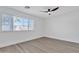 Bright, minimalist bedroom featuring a ceiling fan and ample natural light from a large window at 3050 S Cascade Pl, Chandler, AZ 85248