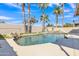 Inviting pool area surrounded by mature palm trees, a rock waterfall feature, and plenty of patio space for relaxing and entertaining at 3050 S Cascade Pl, Chandler, AZ 85248