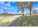 Scenic waterfront view of a tranquil canal with lush green banks, mature trees, and picturesque homes in the background at 3050 S Cascade Pl, Chandler, AZ 85248