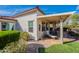 A cozy, covered back patio with stone tile flooring, featuring a chaise lounge and outdoor seating arrangement at 336 N Monterey Ct, Casa Grande, AZ 85194