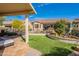 Beautiful backyard featuring a covered patio, artificial turf, and desert landscaping for low-maintenance outdoor living at 336 N Monterey Ct, Casa Grande, AZ 85194