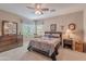 Inviting bedroom with neutral carpet, a ceiling fan, and a comfortable bed decorated with artistic wall decor at 336 N Monterey Ct, Casa Grande, AZ 85194