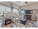 Bright living room with a white leather sofa, ceiling fan, and large windows at 336 N Monterey Ct, Casa Grande, AZ 85194