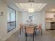 Dining area with modern light fixture and access to kitchen and balcony, creating a functional space at 3420 W Danbury Dr # C216, Phoenix, AZ 85053