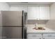 Kitchen with stainless steel refrigerator, white cabinets, and neutral countertops at 3420 W Danbury Dr # C216, Phoenix, AZ 85053