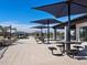 Outdoor dining area with tables and chairs beneath shade umbrellas near community center at 3508 E Audrey Dr, San Tan Valley, AZ 85143