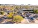 Aerial view of a home with a swimming pool, palm trees, and mountain views at 3531 E Becker Ln, Phoenix, AZ 85028