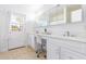 Light filled bathroom featuring double vanity, under cabinet storage, and access to the backyard at 3531 E Becker Ln, Phoenix, AZ 85028