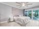 This bedroom features a neutral palette, a padded headboard, and sliding glass doors leading to the outside at 3531 E Becker Ln, Phoenix, AZ 85028