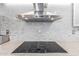 Close-up of a modern cooktop with a sleek stainless steel range hood above it at 3531 E Becker Ln, Phoenix, AZ 85028