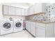 Well-organized laundry room with washer, dryer, sink, and plenty of cabinet storage space at 3531 E Becker Ln, Phoenix, AZ 85028