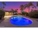 Inviting backyard pool with lounge chairs, umbrellas, and lush landscaping creates a perfect private oasis at 3531 E Becker Ln, Phoenix, AZ 85028