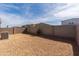 View of the backyard showcasing the block wall and low-maintenance gravel at 36529 W San Capistrano Ave, Maricopa, AZ 85138