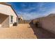 View of the backyard showcasing the block wall and low-maintenance gravel at 36529 W San Capistrano Ave, Maricopa, AZ 85138