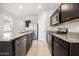 Modern kitchen featuring stainless steel appliances, granite countertops, and a breakfast bar at 36529 W San Capistrano Ave, Maricopa, AZ 85138