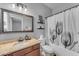 Cozy bathroom featuring a granite countertop, framed mirror, tulip shower curtain, and elegant lighting at 3707 N 188Th Ave, Litchfield Park, AZ 85340