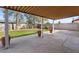 Back patio with a covered area, beautiful flowerpots, and a well-maintained grassy area at 3724 E Joan De Arc Ave, Phoenix, AZ 85032