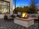 Inviting back patio with a stone fireplace, outdoor seating, and professional landscaping at 4109 N 57Th St, Phoenix, AZ 85018