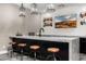 Entertainer's wet bar with seating, marble countertop and backsplash, floating display shelves, and sink at 4109 N 57Th St, Phoenix, AZ 85018