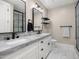 Well-lit bathroom featuring a double sink vanity with marble counters, modern fixtures, and hexagon tile flooring at 4109 N 57Th St, Phoenix, AZ 85018