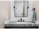 Modern bathroom vanity featuring a gray countertop, black faucet and fixtures with a large framed mirror at 4109 N 57Th St, Phoenix, AZ 85018