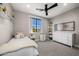 Bright bedroom with a twin bed, window, dresser, ceiling fan, carpet and neutral colored walls at 4109 N 57Th St, Phoenix, AZ 85018