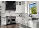 Bright kitchen with stainless steel Wolf range, white cabinetry, marble countertops, backsplash, and sink at 4109 N 57Th St, Phoenix, AZ 85018