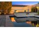 Luxurious pool area with a waterfall feature, cozy seating, and ambient lighting for evening relaxation at 4109 N 57Th St, Phoenix, AZ 85018