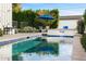 Refreshing pool with a blue umbrella, manicured hedges, and elegant water feature at 4109 N 57Th St, Phoenix, AZ 85018