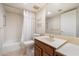 A clean bathroom features a shower-tub combo with white tile and a wooden vanity with countertop space at 4200 N Miller Rd # 220, Scottsdale, AZ 85251