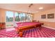 Bright game room featuring a red billiard table and a large window with tropical views at 4200 N Miller Rd # 220, Scottsdale, AZ 85251