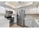 White kitchen showcasing stainless steel appliances, plenty of cabinetry, and countertop space at 4200 N Miller Rd # 220, Scottsdale, AZ 85251