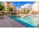 Inviting community pool area surrounded by lounge chairs, landscaping, and multi-story residential buildings at 4200 N Miller Rd # 220, Scottsdale, AZ 85251