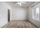 Bright bedroom featuring a ceiling fan, a window overlooking the neighborhood, and plank flooring at 4455 E Paradise Village S Pkwy # 1068, Phoenix, AZ 85032