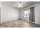 Well-lit bedroom with a ceiling fan, a window overlooking the neighborhood, and plank flooring at 4455 E Paradise Village S Pkwy # 1068, Phoenix, AZ 85032