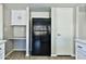 Kitchen area with black refrigerator, white cabinets, and a built-in desk at 4536 W Bloomfield Rd, Glendale, AZ 85304