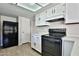 View of the kitchen featuring a black range and ample white cabinetry at 4536 W Bloomfield Rd, Glendale, AZ 85304