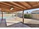 Covered patio overlooks the backyard with pool surrounded by a metal fence, rock and grass at 4536 W Bloomfield Rd, Glendale, AZ 85304