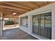 Covered patio with sliding glass doors and shade blind windows overlooking the backyard at 4536 W Bloomfield Rd, Glendale, AZ 85304