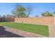 A backyard featuring a low brick wall, gravel borders, and lush, green, well-maintained artificial lawn at 4960 S Huachuca Pl, Chandler, AZ 85249