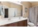 Bathroom with double sink vanity, large mirror, and shower with neutral patterned curtain at 4960 S Huachuca Pl, Chandler, AZ 85249